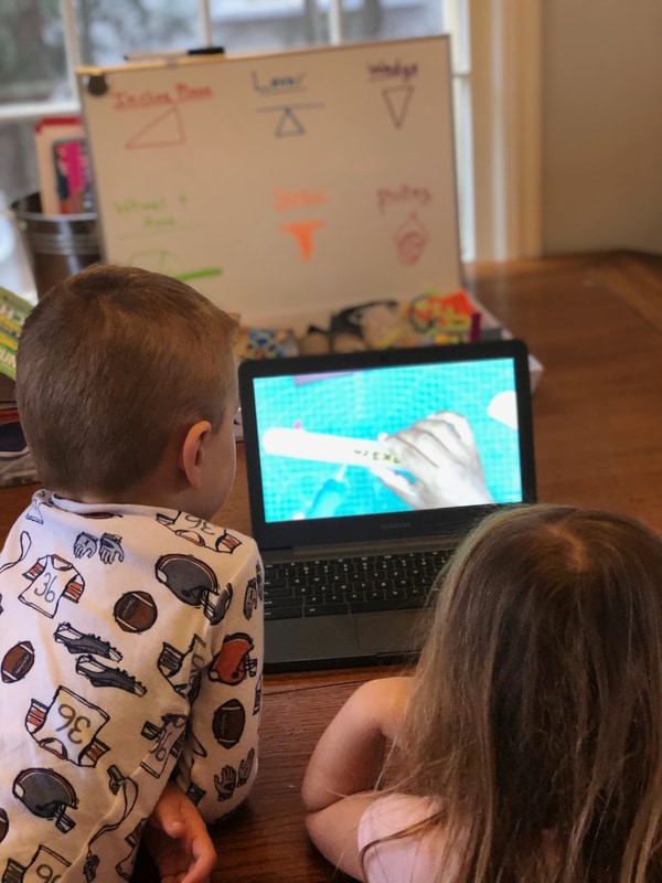 Young kids learning from a broadcasted program.