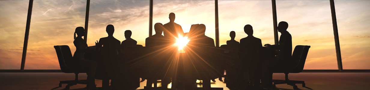 people sitting at a conference table in front of a large window